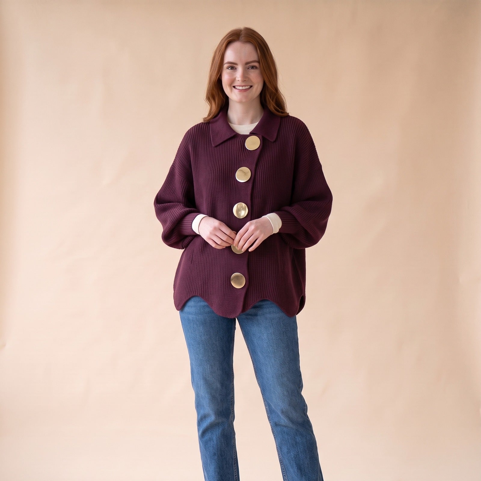 Woman in an oversized wine knit cardigan with gold buttons